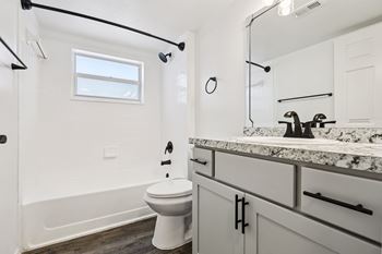 A white toilet sits in a bathroom with a marble counter.